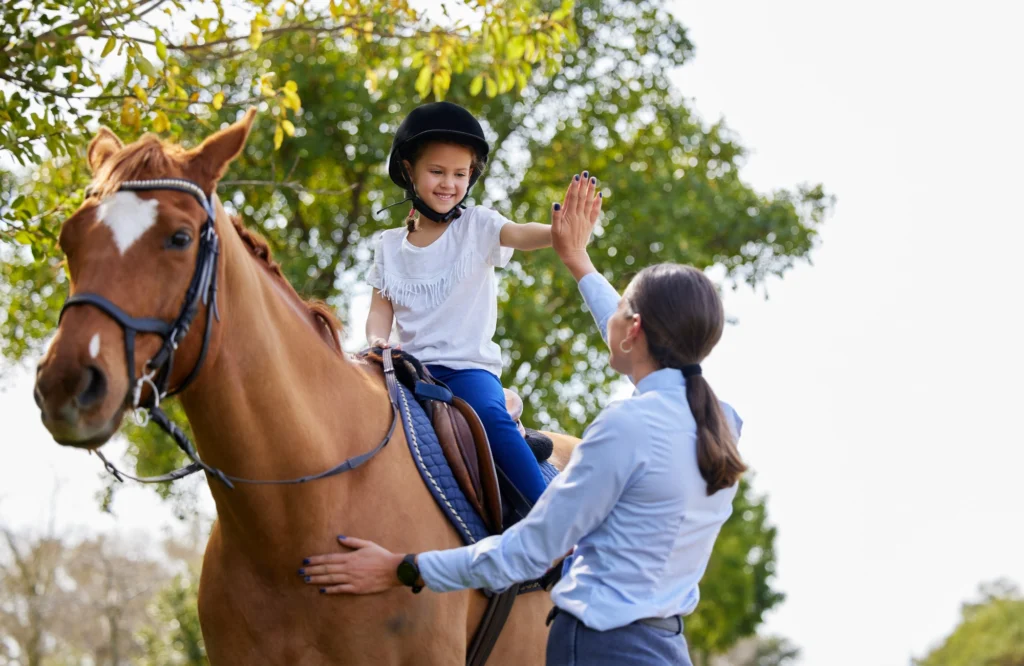immagine che ritrae mamma e figlia durante una lezione di equitazione
